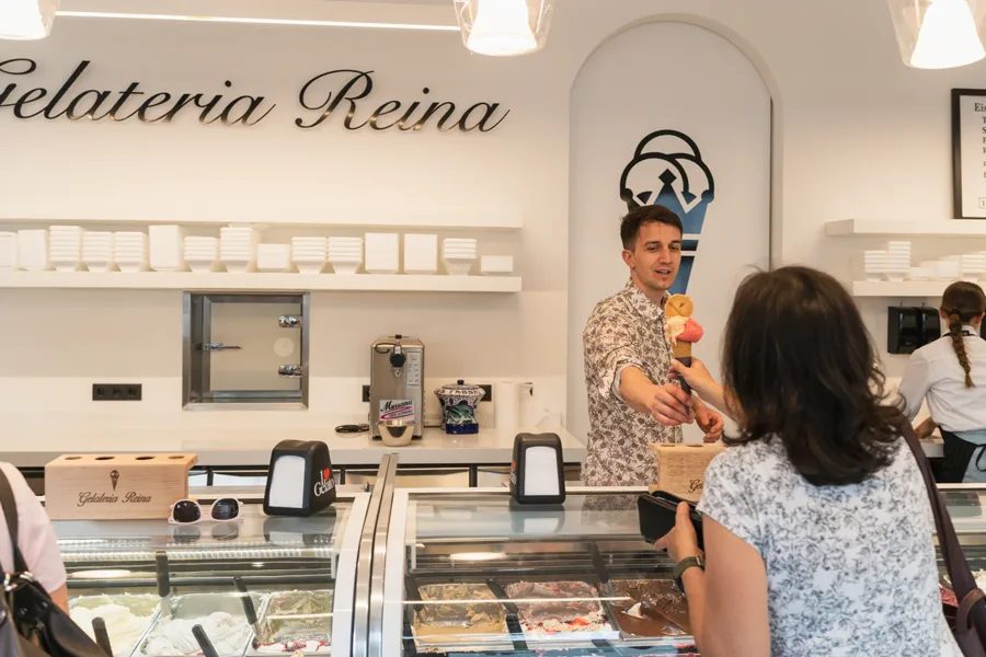 Übergabe einer Eiswaffel über die Theke